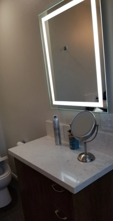 Quartz vanity countertop with backlit LED mirror in a Fresno, CA bathroom remodel