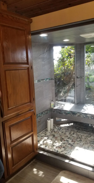 Custom oak bathroom cabinetry beside a glass walk-in shower in a Clovis, CA remodel