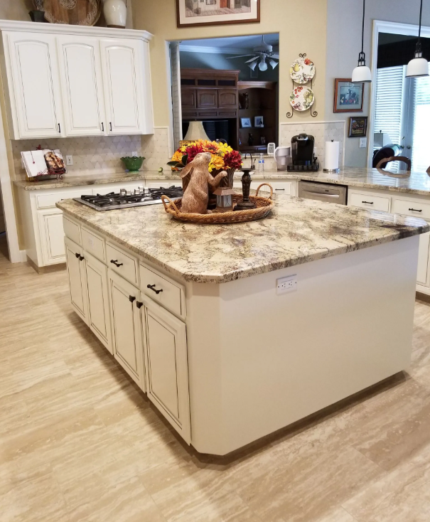 Large granite kitchen island with gas cooktop and cream cabinets in a Fresno, CA remodel