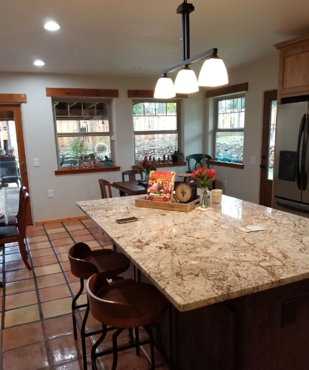 Open kitchen with granite island, pendant lights and Saltillo tile floor in a Clovis, CA remodel