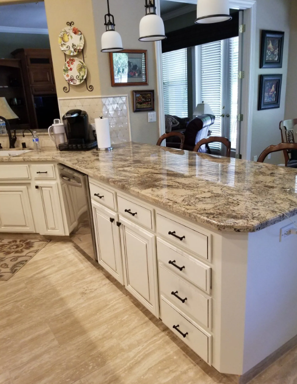 Granite peninsula countertop over cream cabinets with oil-rubbed bronze pulls in Fresno, CA