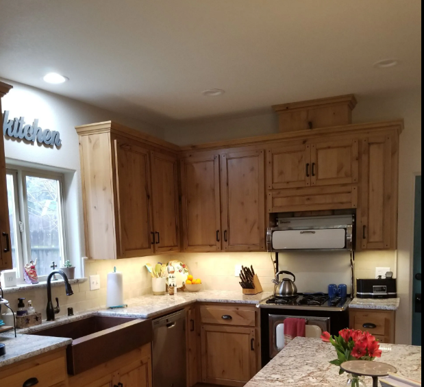Knotty alder kitchen cabinets with under-cabinet lighting and copper farmhouse sink in Madera, CA